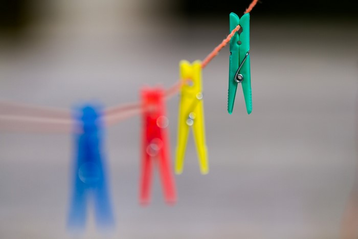 Four colorful clothespins on a clothesline