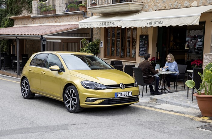 Yellow 2017 Volkswagen Golf TDI parked near a cafe