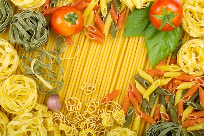 Tomatoes and various pasta shapes with basil and garlic