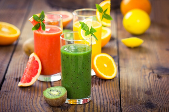 Assortment of Fresh Juices and Fruits on Wooden Table