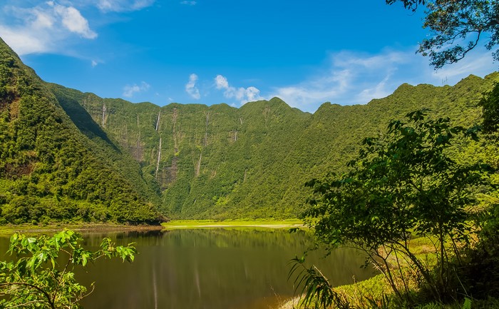 Lake and waterfalls in a mountainous forest landscape