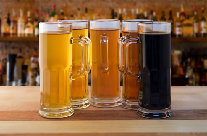 Five beer mugs on a bar counter
