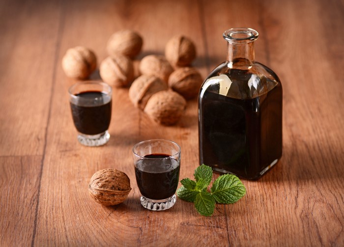Walnut liqueur in bottle and shot glasses with walnuts