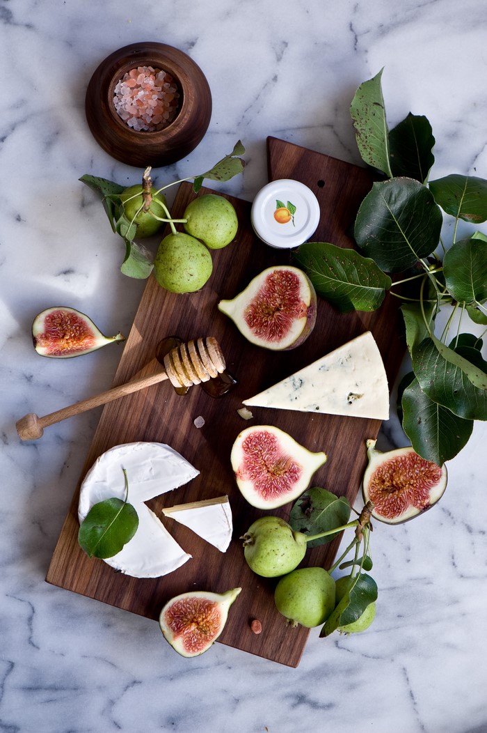 Cheese board with figs, pears, honey, and salt