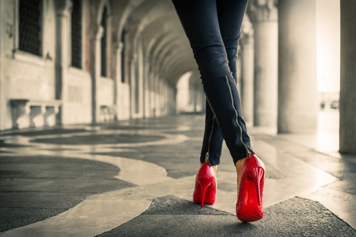 Legs in red stilettos walking through an arcade