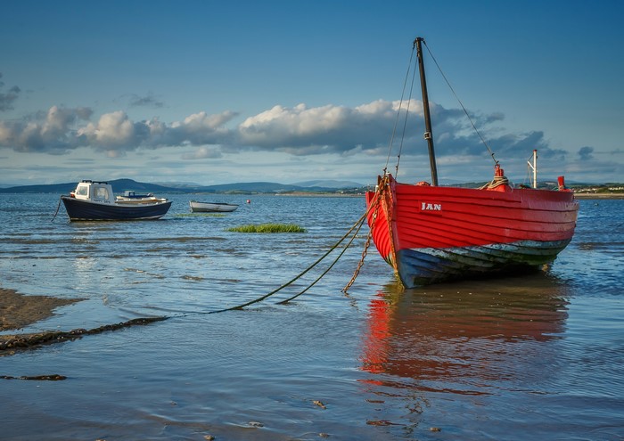Red fishing boat named Jan moored in Morecambe Bay, UK