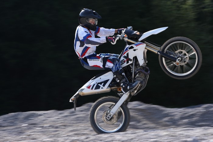Motorcyclist performing a wheelie on a BMW G 450 X