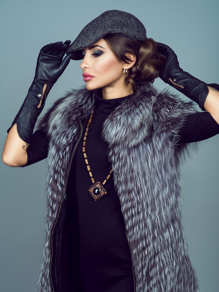 Woman in fur vest, hat, and gloves