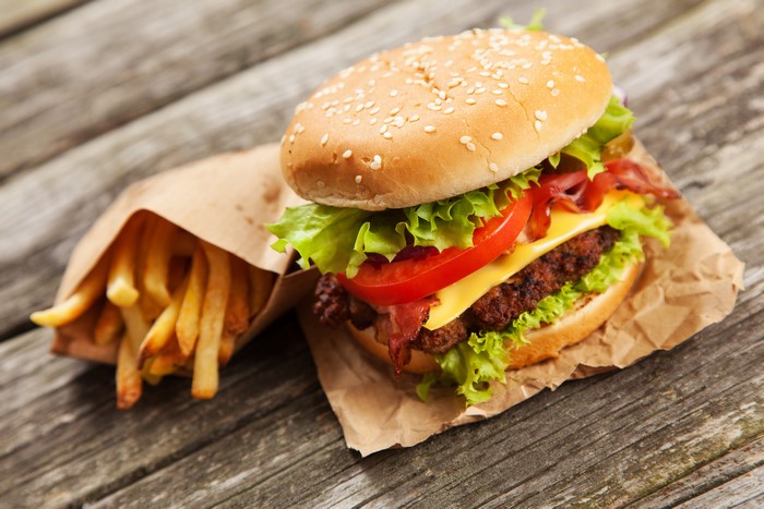 Hamburger and French fries on wood planks