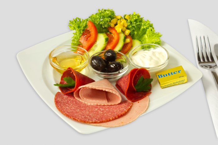 Breakfast plate with sausage, olives, and salad