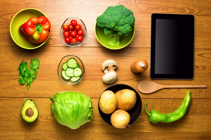 Vegetables and Tablet on Wood Planks