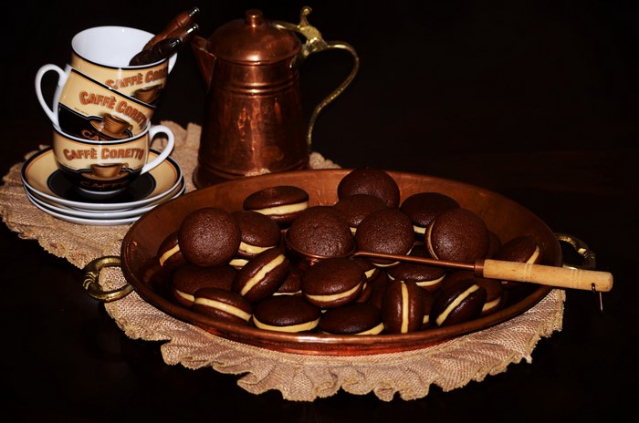Chocolate cookies with cream filling and coffee cups