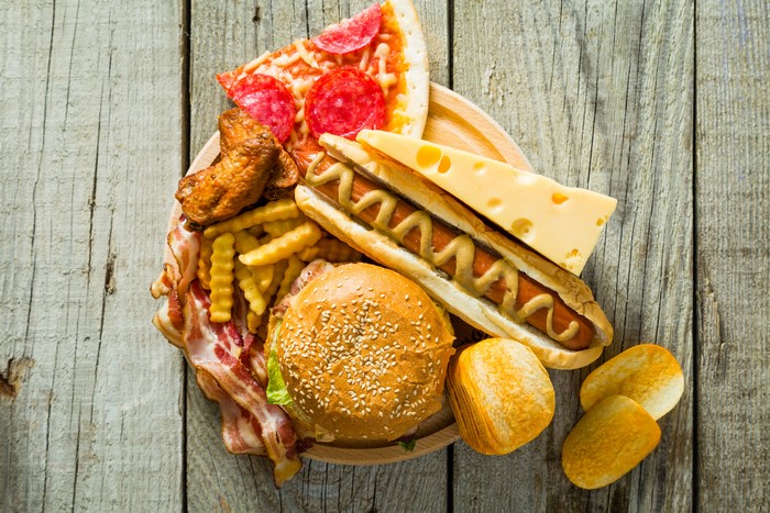 Fast food platter with pizza, hot dog, burger, fries, and cheese
