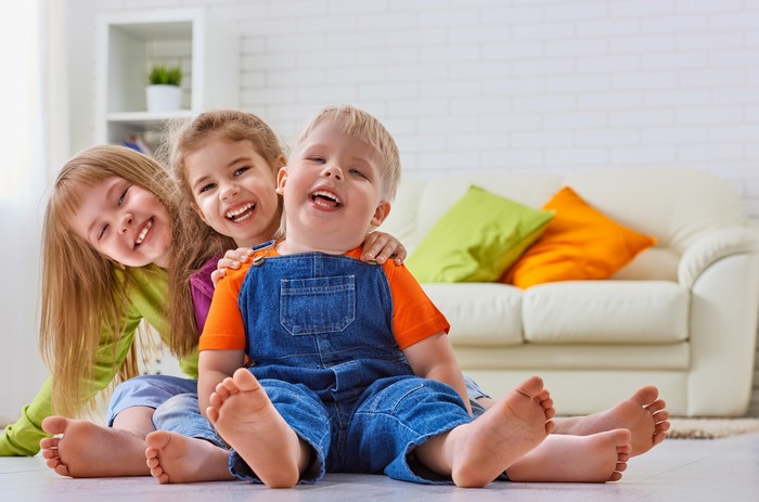 Three Children Smiling on Floor