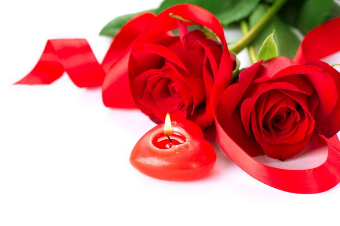 Two red roses with a heart candle and ribbon