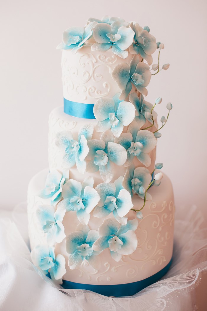 Three-tier white cake with blue orchids
