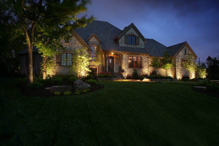 Stone house with landscape lighting at night