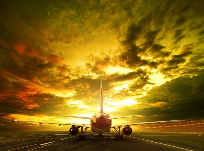 Airplane on runway at sunset