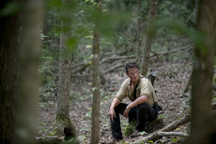Rick Grimes from The Walking Dead sitting in a forest