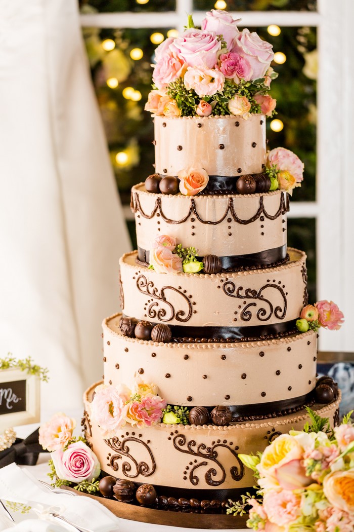 Multi-tiered chocolate wedding cake with roses and chocolates