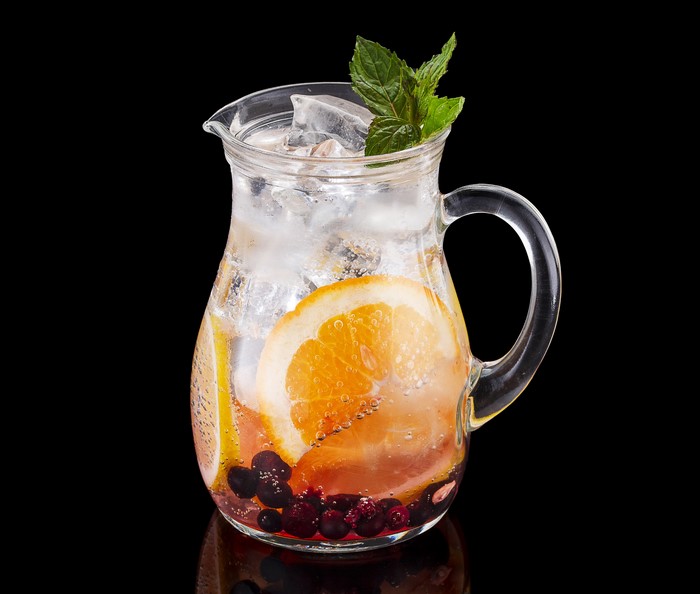 Pitcher of infused water with orange slices and berries