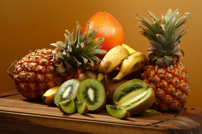 Pineapples, Kiwis, Bananas, and Grapefruit on a Wooden Board