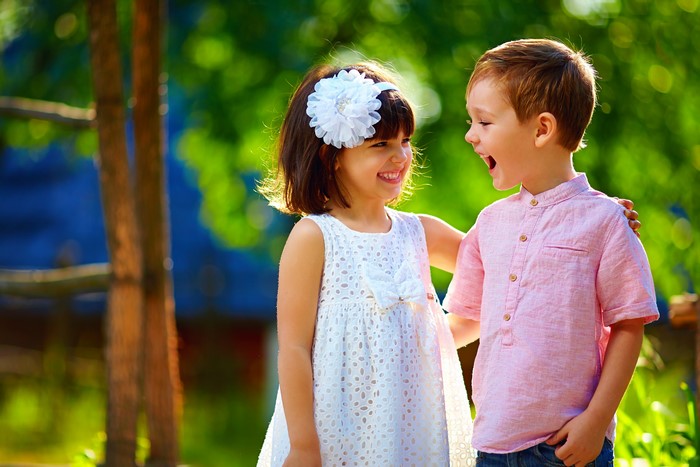 Two children smiling outdoors