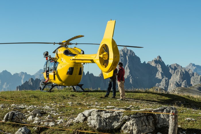 Yellow helicopter on a mountain with people