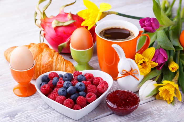 Easter Breakfast with Coffee, Croissant, Eggs, Berries, and Flowers