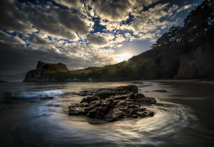 Sunset over a rocky coast in Tasman, New Zealand