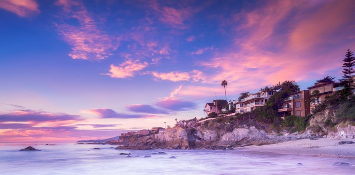 Houses on a cliff overlooking the ocean at sunset in Laguna Beach, California