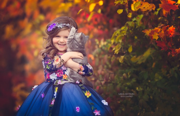 Girl in floral dress holding a cat
