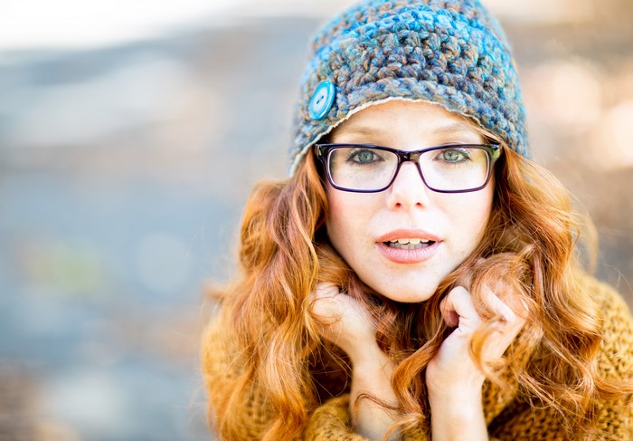Redhead girl with glasses wearing a winter hat