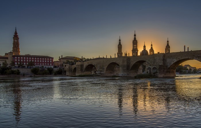 Stone bridge over a river at sunset in Zaragoza, Aragon, Spain