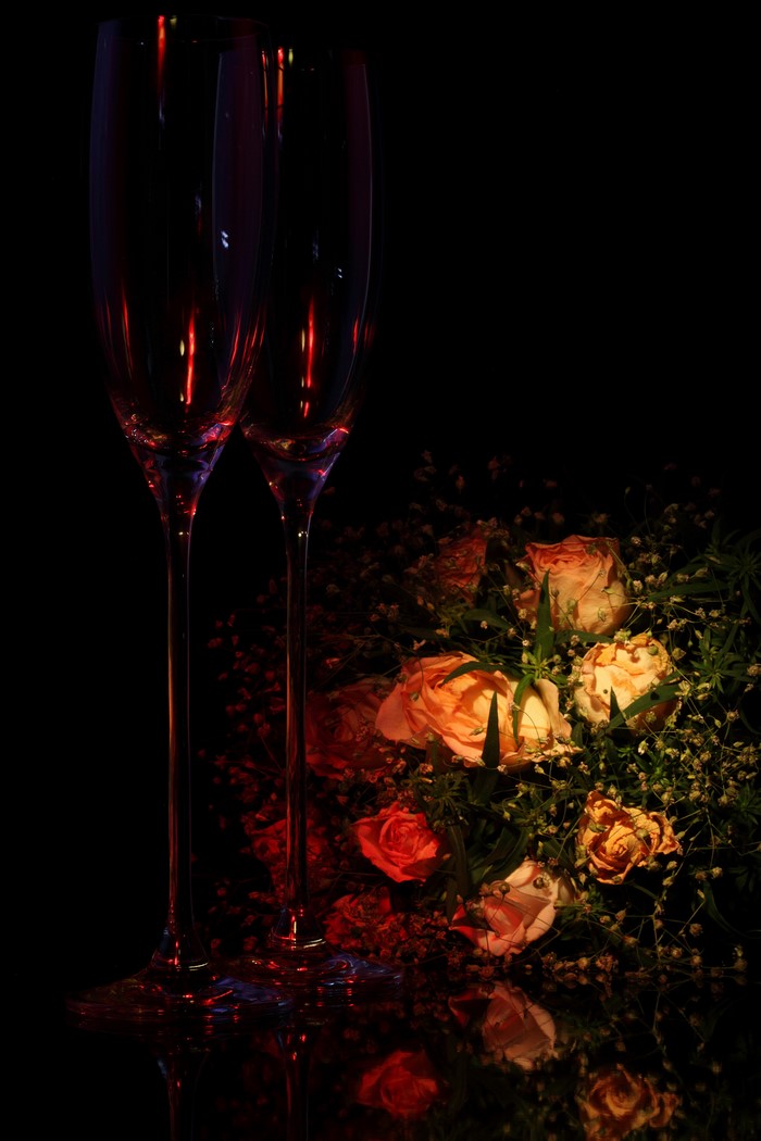Two champagne glasses with a bouquet of roses