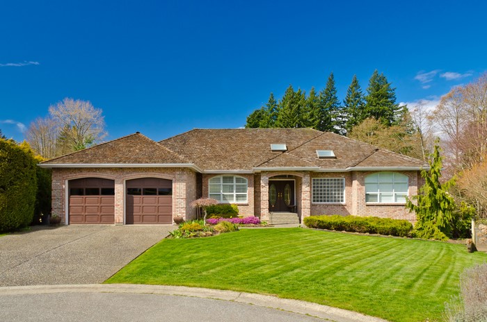 Brick house with garage and manicured lawn