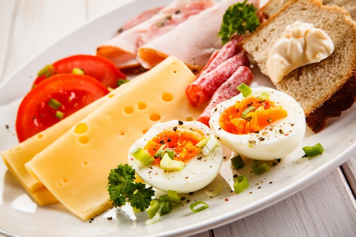 Breakfast plate with cheese, sausage, eggs, and bread