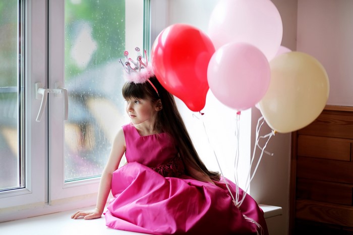 Girl in a Crown and Dress with Balloons by Window
