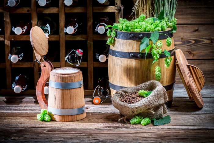 Wooden barrel with hops, grain, and beer mug