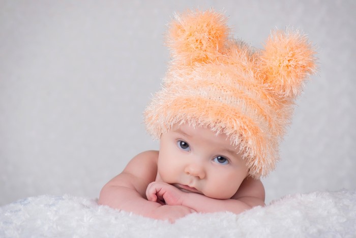 Baby wearing a fluffy orange winter hat