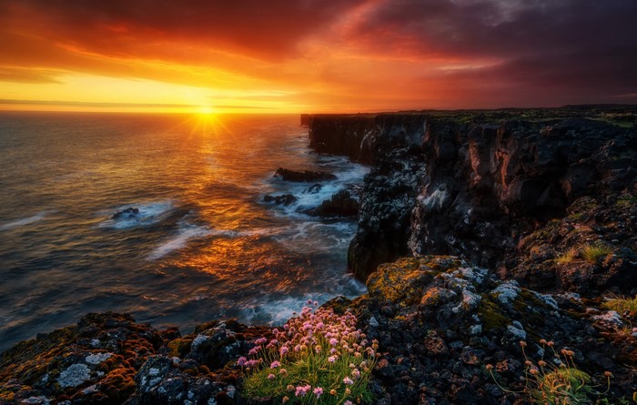 Sunset over the coast of Iceland with crashing waves