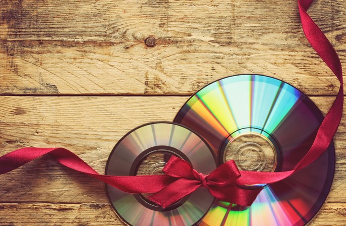 CDs tied with a red ribbon on wooden planks