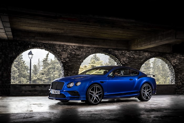 Blue Bentley Continental Supersports parked under stone arches
