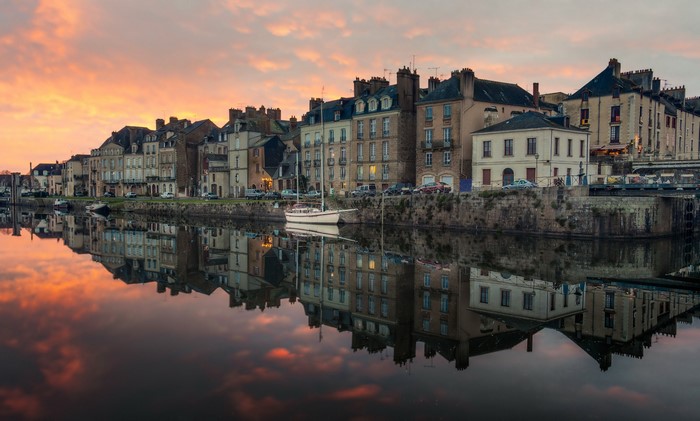 Houses reflecting in river at sunset in Redon, Brittany, France