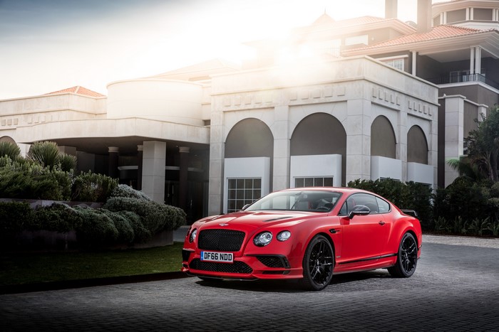 Red Bentley Continental Supersports in front of a building