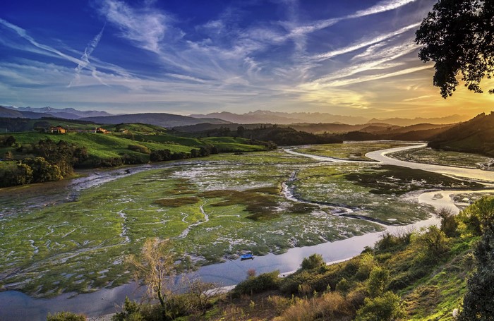 River estuary and green hills at sunset in Cantabria, Spain