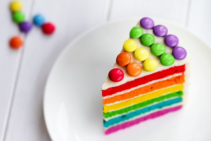 Slice of rainbow cake with candy toppings
