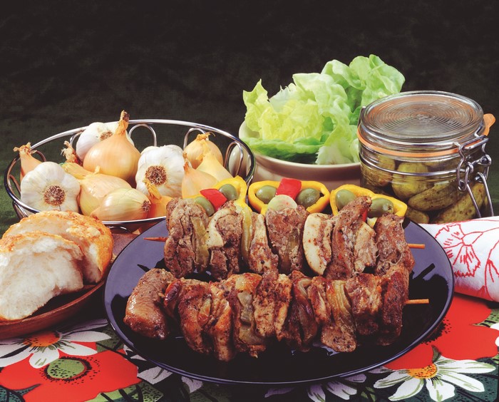 Shashlik with onions, garlic, bread, and pickles
