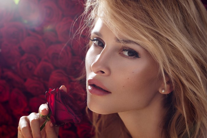 Woman with blonde hair holding a red rose