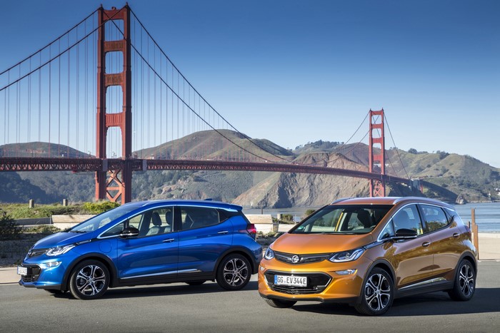 Two Opel Ampera-e cars in front of Golden Gate Bridge